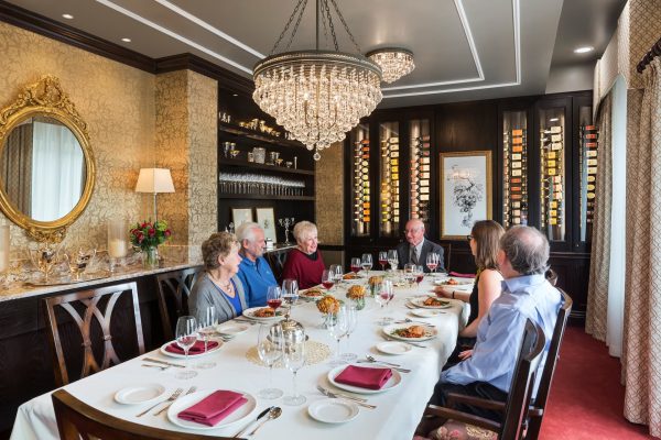 Residents sitting at a long dining table, sharing a meal