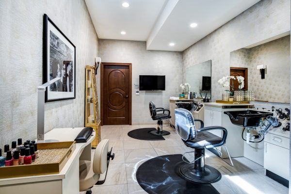 A salon with two salon chairs and washing stations, and a manicure station