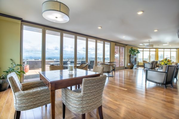 A seating area with tables, chairs, and large windows