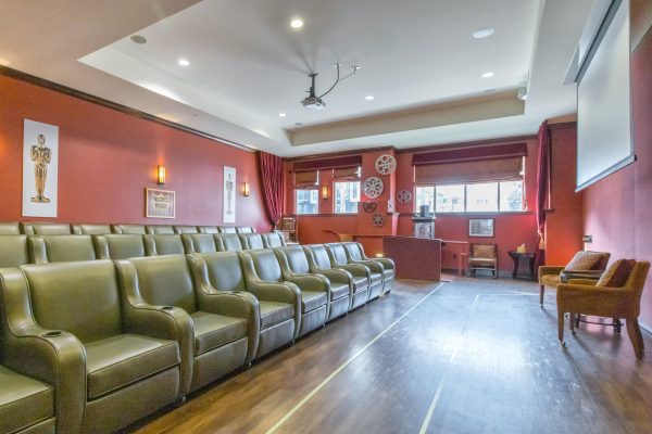 Several green armchairs inside the movie theater