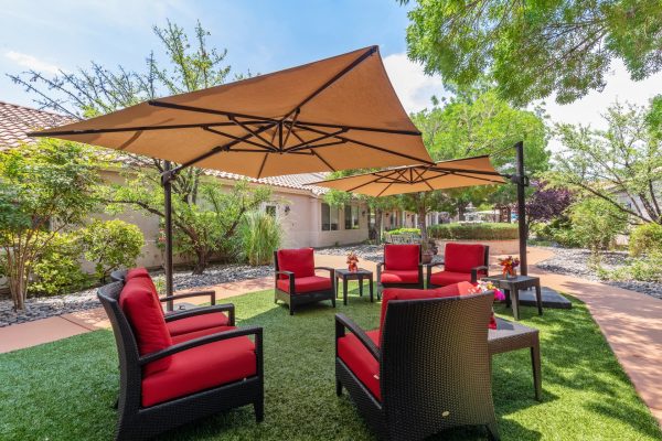 An outdoor seating area with red chairs and umbrellas