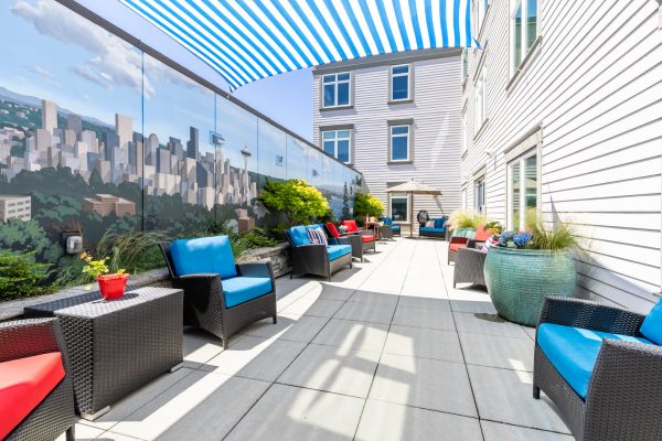 A covered outside seating area with blue and red chairs