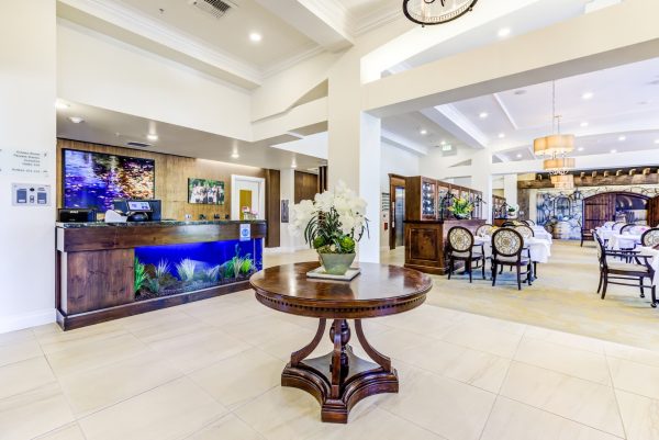 The lobby with a round table, desk with built-in aquarium, and tables and chairs