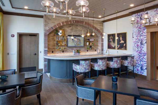 A unique bar area with colorful chairs and a brick wall in the background