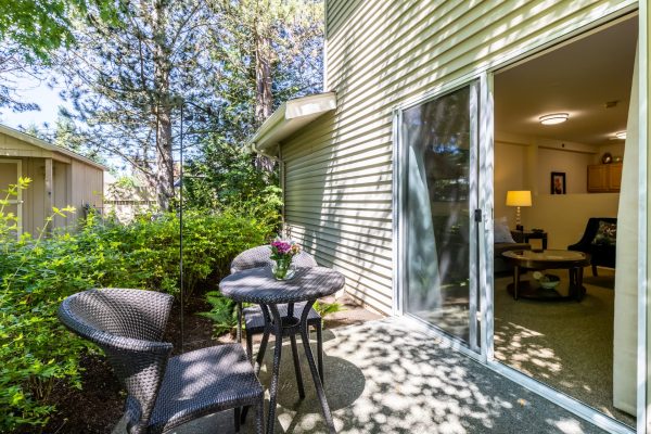 A small patio outside of the living room with a table and two chairs