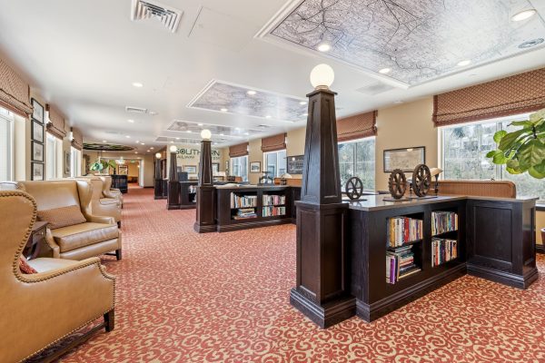 A library with low bookshelves and armchairs