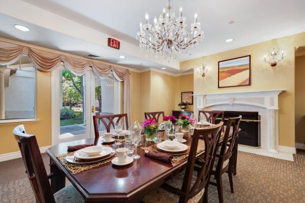 A large dining table with a fireplace in the background