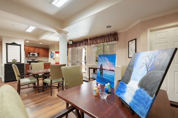 A kitchen area with painting and puzzle stations at two separate tables