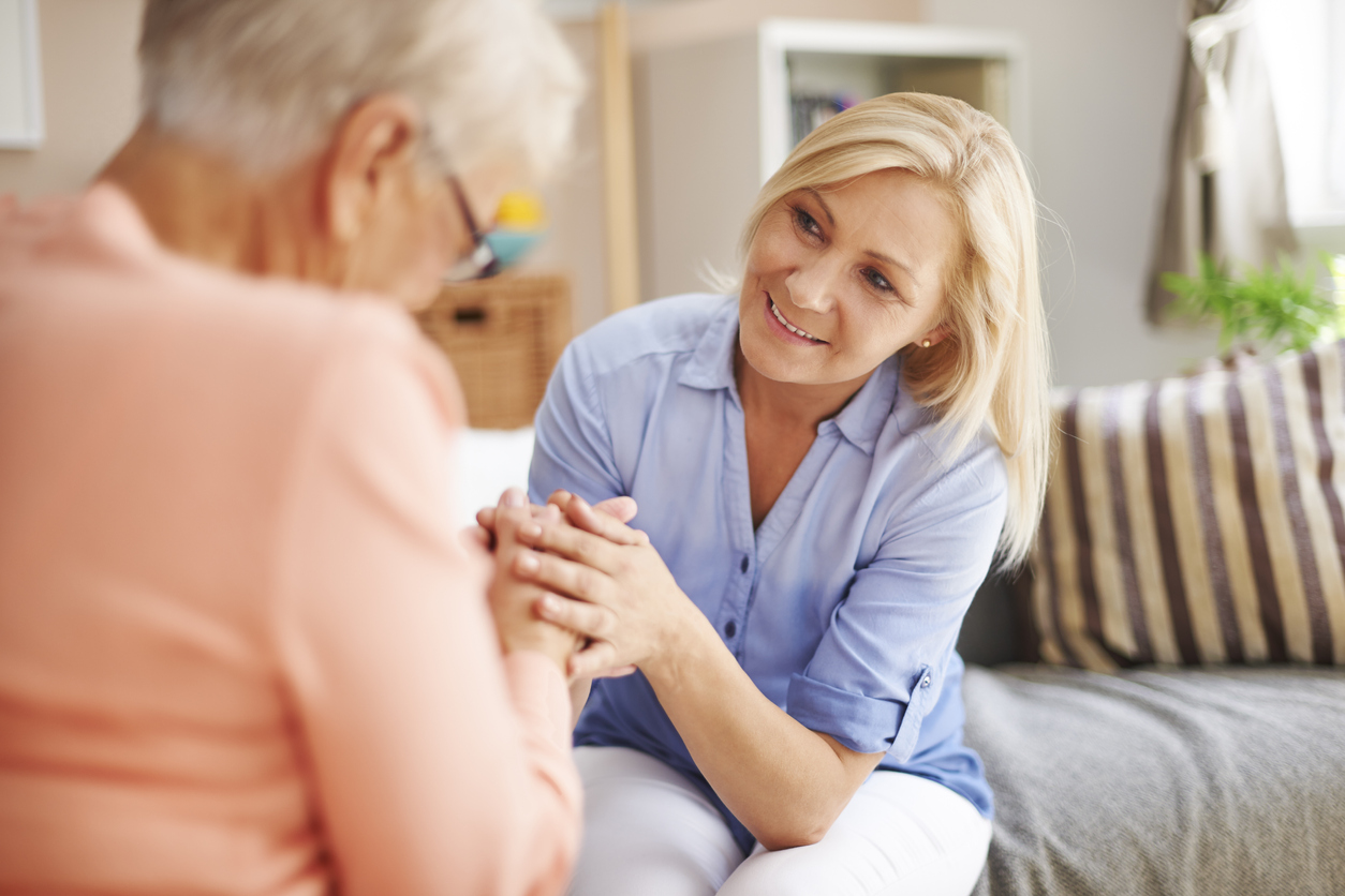 A woman holding a resident’s hands