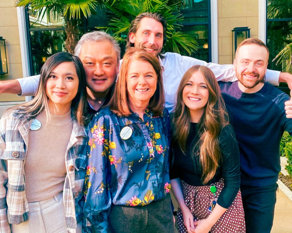 A group of employees smiling outside