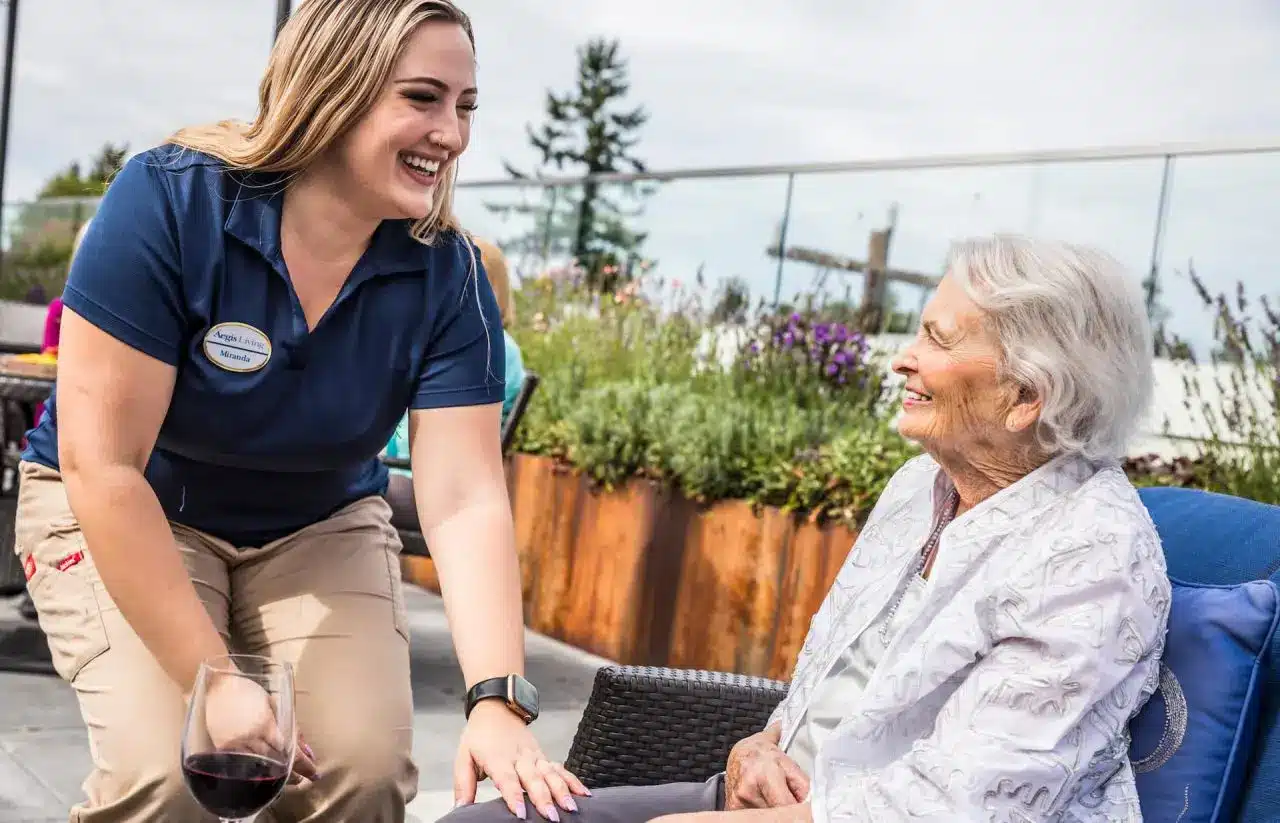Aegis caregiver talking with a Senior enjoying a glass of wine