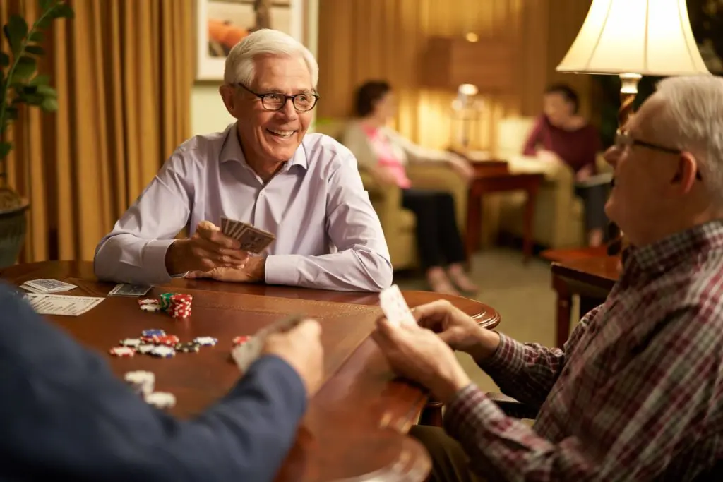 Seniors playing poker in cozy living room.